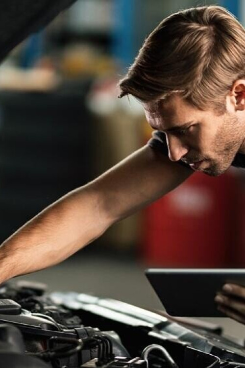 1760536822_car-mechanic-examining-engine-malfunction-while-using-touchpad-auto-repair-sho